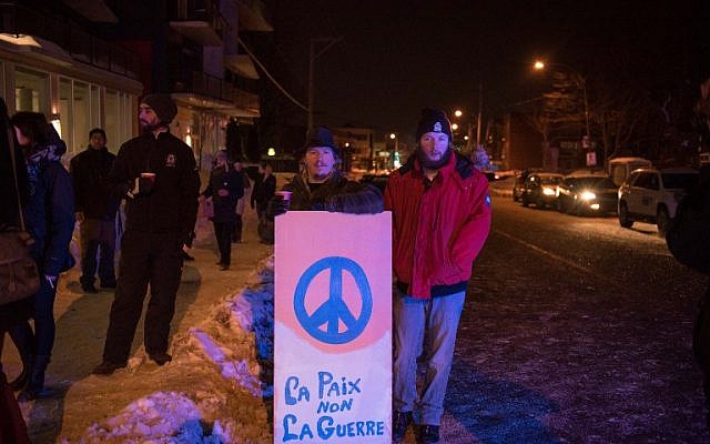 People stand with a peace sign near the Québec City Islamic cultural center after a shooting in the mosque on Sainte-Foy Street in Quebec city on January 29, 2017. (AFP/Alice Chiche) People stand with a peace sign near the Québec City Islamic cultural center after a shooting in the mosque on Sainte-Foy Street in Quebec city on January 29, 2017. (AFP/Alice Chiche)
