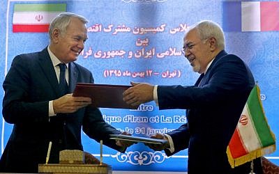 French Foreign Minister Jean-Marc Ayrault (L) and Iranian Foreign Minister Mohammad Javad Zarif exchange documents after signing economic agreements in Tehran on January 31, 2017.(AFP PHOTO / ATTA KENARE)
