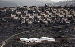 New prefabricated homes are seen under construction in the West Bank between the Israeli outpost of Amona and the settlement of Ofra (background), north of Ramallah, on January 31, 2017. (AFP/Thomas Coex)