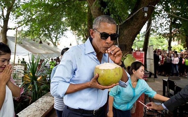'The President sips from a coconut during his visit in Luang Prabang, Laos. This was just after it was chopped open, splattering pieces of coconut on his shirt,' Sept. 7, 2016. (Official White House photo/Pete Souza)
