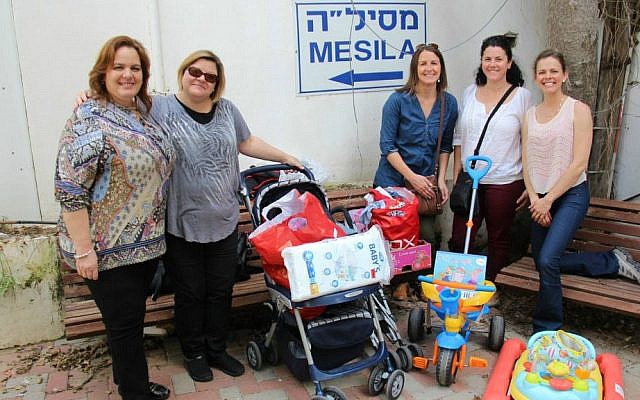 Julie Fisher (second from left) and her Diplomatic Spouses of Israel co-president Rocio Gonzales of Peru and other diplomatic spouses deliver donations to Mesila, and aid and information center for refugees and migrant workers in Tel Aviv. (Mesila)