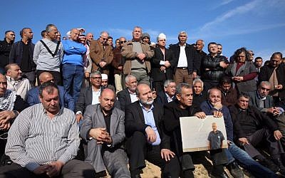 MK Ayman Odeh (back row, with white bandage on head) of the Joint List and other Arab Israeli leaders stand at the scene of fatal clashes in the Bedouin village of Umm al-Hiran, on Wednesday, January 18, 2017 (courtesy)