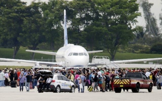 People stand on the tarmac at the Fort Lauderdale-Hollywood International Airport after a shooter opened fire inside a terminal of the airport, killing several people and wounding others before being taken into custody, Friday, Jan. 6, 2017, in Fort Lauderdale, Fla. (AP/Lynne Sladky)