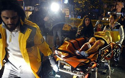 Medics carry a wounded person at the scene of a shooting attack at a popular nightclub in Istanbul, early Sunday, Jan. 1, 2017. (IHA via AP)