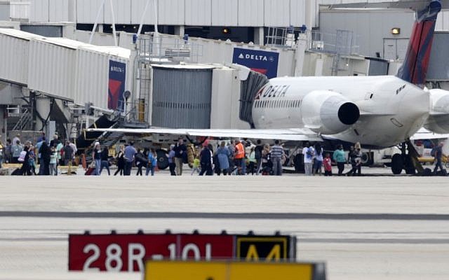 People stand on the tarmac at the Fort Lauderdale-Hollywood International Airport after a shooter opened fire inside the terminal, killing several people and wounding others before being taken into custody, Friday, Jan. 6, 2017, in Fort Lauderdale, Fla. (AP Photo/Lynne Sladky)