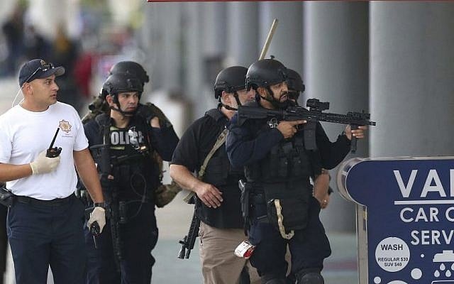 Law enforcement officers walk around Fort Lauderdale-Hollywood International Airport, Friday, Jan. 6, 2017, in Fort Lauderdale, Fla. (David Santiago/El Nuevo Herald via AP)