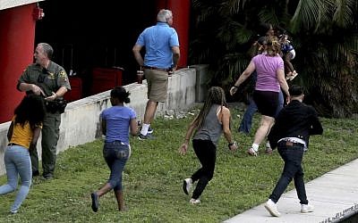 People flee the area outside the Fort Lauderdale-Hollywood International airport after a shooting took place Friday, Jan. 6, 2017 in Fort Lauderdale, Fla. (Mike Stocker/South Florida Sun-Sentinel via AP)