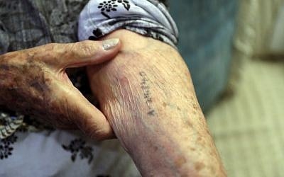In this Dec.19, 2016 photo, Auschwitz survivor Cyrla Gewertz shows a number tattooed on her arm when she was a prisoner at the concentration camp, during an interview in Sao Paulo, Brazil. (AP Photo/Andre Penner)