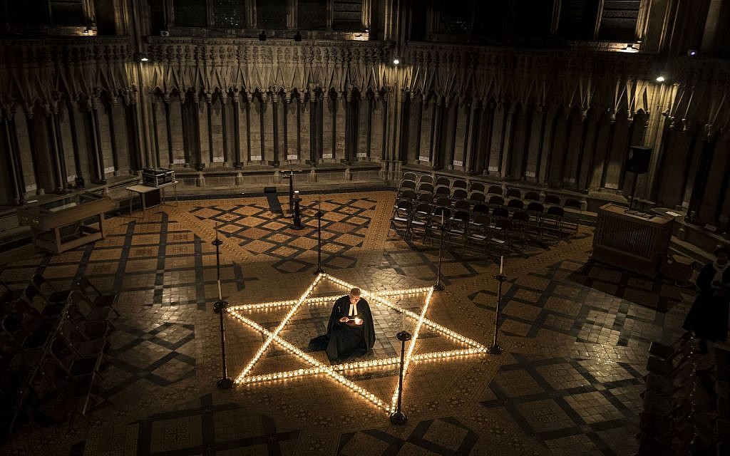 Canon Chancellor Christopher Collingwood helps light one of 600 candles in the shape of the Star of David to commemorate Holocaust Memorial Day at York Minster, York,, England, Thursday, Jan. 26, 2017. (Danny Lawson/PA via AP)