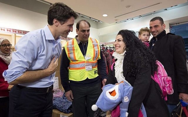 Canadian Prime Minister Justin Trudeau, left, greets Georgina Zires, center, Madeleine Jamkossian, second right, and her father Kevork Jamkossian, refugees fleeing from Syria, as they arrive at Pearson International airport, in Toronto, December 11, 2015. (Nathan Denette/The Canadian Press via AP) Canadian Prime Minister Justin Trudeau, left, greets Georgina Zires, center, Madeleine Jamkossian, second right, and her father Kevork Jamkossian, refugees fleeing from Syria, as they arrive at Pearson International airport, in Toronto, December 11, 2015. (Nathan Denette/The Canadian Press via AP)