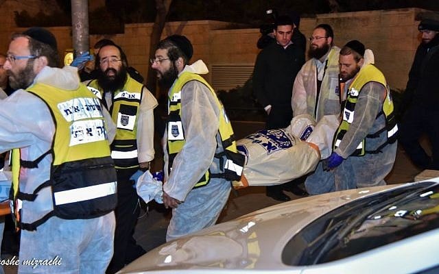 ZAKA rescue personnel carry the bodies of family members at the scene where a woman and four children were killed in a fire in what police suspect was a murder-suicide at an apartment in Jerusalem, January 1, 2017.  (Moshe Mizrahi/ZAKA)