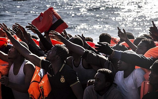 Migrants reach out for floatation vests waiting to board the MV Aquarius, as 193 people and two corpses are recovered Friday Jan. 13, 2017, from international waters in the Mediterranean Sea about 22 miles (35 Km) north of Sabrata, Libya. (AP Photo/Sima Diab) Migrants reach out for floatation vests waiting to board the MV Aquarius, as 193 people and two corpses are recovered Friday Jan. 13, 2017, from international waters in the Mediterranean Sea about 22 miles (35 Km) north of Sabrata, Libya. (AP Photo/Sima Diab)
