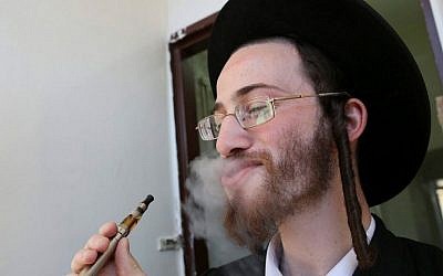 An ultra-Orthodox Jewish man seen smoking an electric cigarette. September 23, 2012. (Nati Shohat/Flash90)