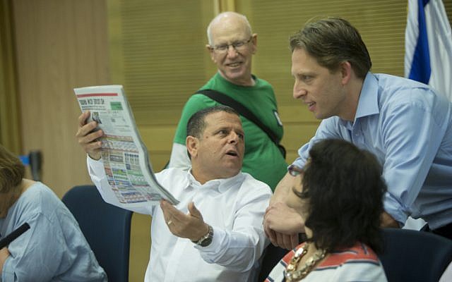 Zionist Union MK Eitan Cabel (D-C) holds up the Israel Hayom daily newspaper during an Economy Committee meeting regarding the new public broadcasting corporation at the Knesset on August 2, 2016. (Yonatan Sindel/Flash90) Zionist Union MK Eitan Cabel (D-C) holds up the Israel Hayom daily newspaper during an Economy Committee meeting regarding the new public broadcasting corporation at the Knesset on August 2, 2016. (Yonatan Sindel/Flash90)