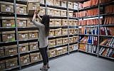 A worker of the Israel State Archives looks at classified documents related to the Yemenite Children Affair in Jerusalem, December 22, 2016. (Yonatan Sindel/Flash90)