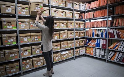 A worker of the Israel State Archives looks at classified documents related to the Yemenite Children Affair in Jerusalem, December 22, 2016. (Yonatan Sindel/Flash90)