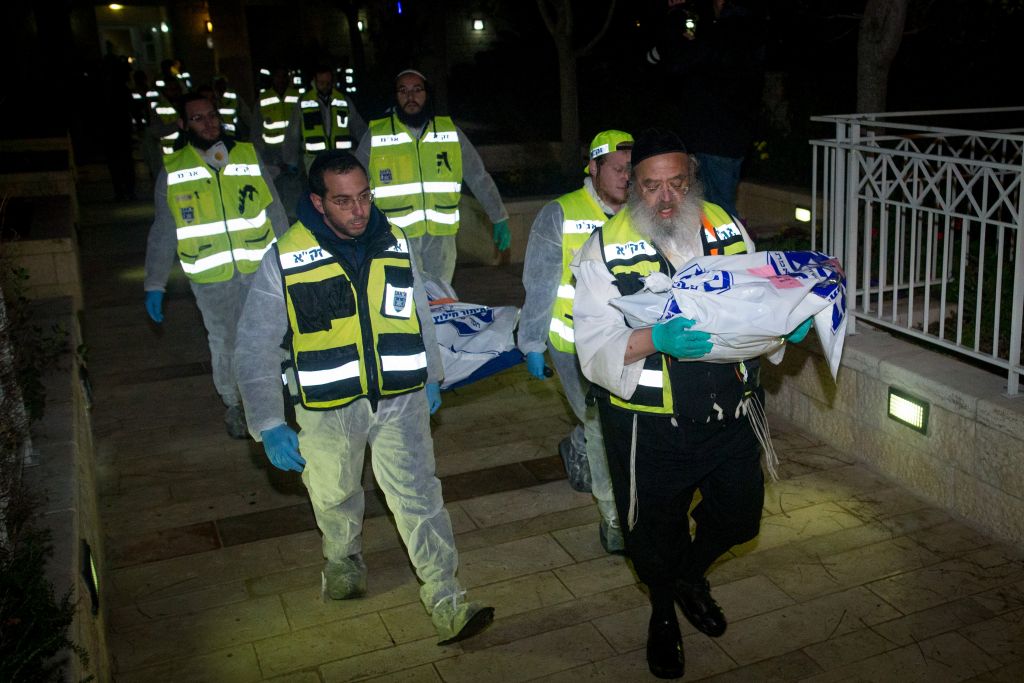 ZAKA rescue personnel carry the bodies of family members at the scene where a woman and four children were killed in a fire in what police suspect was a murder-suicide at an apartment in Jerusalem, January 1, 2017. (Yonatan Sindel/Flash90) ZAKA rescue personnel carry the bodies of family members at the scene where a woman and four children were killed in a fire in what police suspect was a murder-suicide at an apartment in Jerusalem, January 1, 2017. (Yonatan Sindel/Flash90)