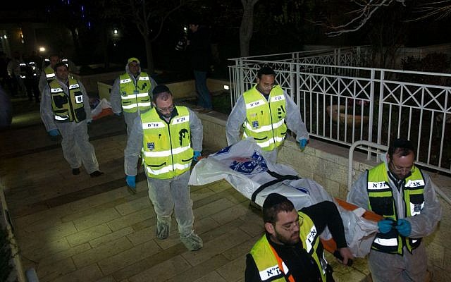 ZAKA rescue personnel carry the bodies of family members at the scene where a woman and four children were killed in a fire in what police suspect was a murder-suicide at an apartment in Jerusalem, January 1, 2017. (Yonatan Sindel/Flash90)