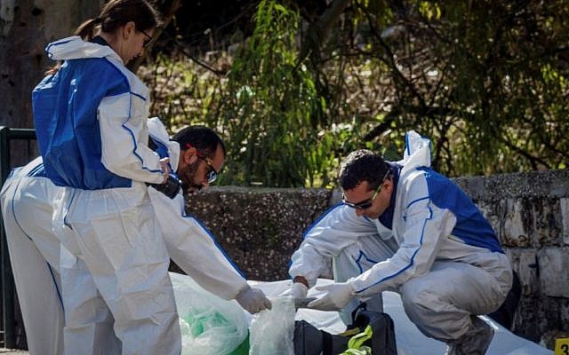 Forensic examiners investigate the scene where a man was murdered after unknown gunmen opened fire, killing one person, in Haifa January 3, 2017. (Meir Vaknin/Flash90) Forensic examiners investigate the scene where a man was murdered after unknown gunmen opened fire, killing one person, in Haifa January 3, 2017. (Meir Vaknin/Flash90)