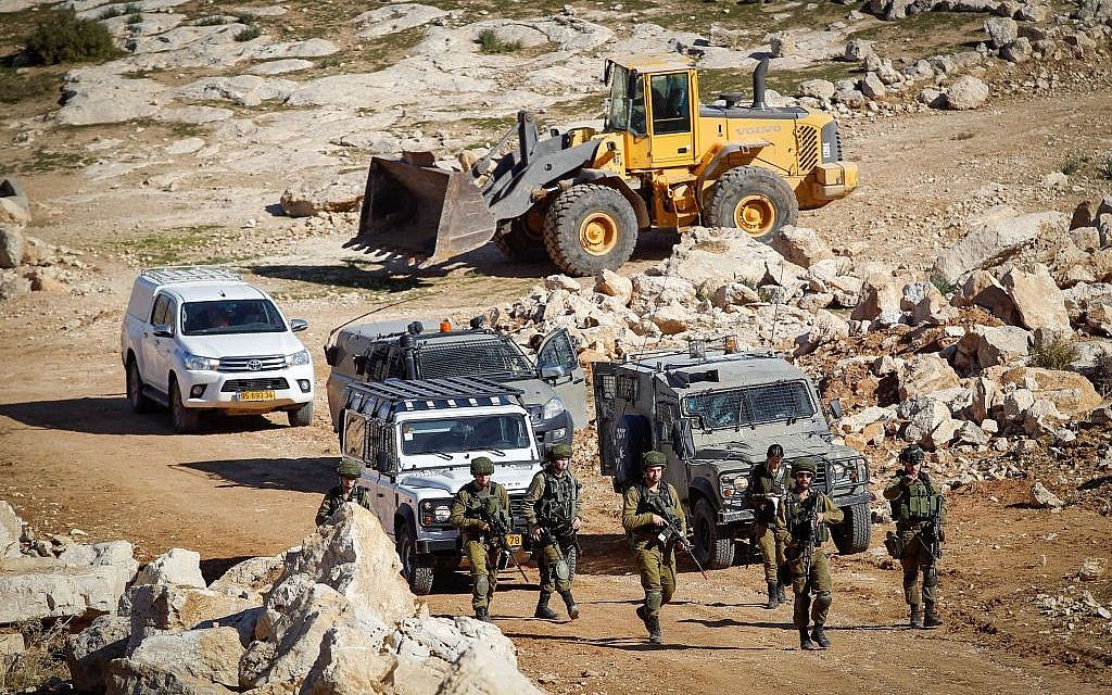 Soldiers guard as an army bulldozer blocks the road near the West Bank village of Bani Naim, January 11, 2017. (Wisam Hashlamoun/Flash90)