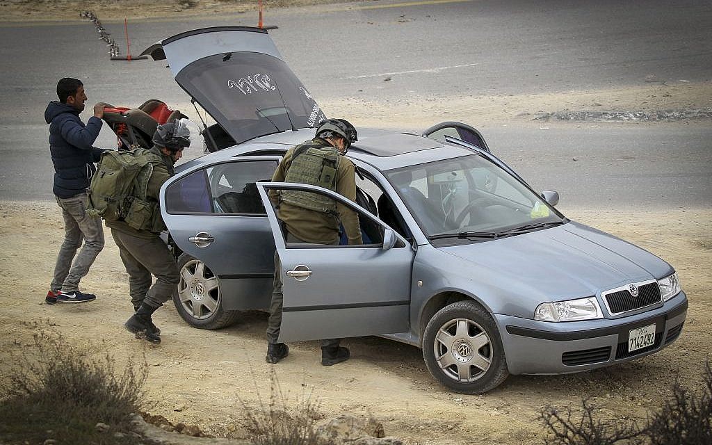 Border Police officers search a Palestinian vehicle in the West Bank village of Bani Na'im on January 26, 2017 (Photo by Wisam Hashlamoun/Flash90)