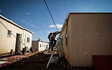 Construction workers work on clearing land for new caravans in the Jewish settlement of Ofra, in the West Bank, on January 29, 2017. (Yaniv Nadav/FLash90)