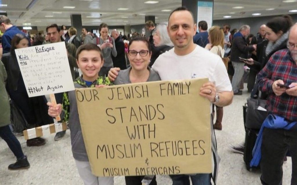 Jacob, left, Miri and Tal Zlotnitsky holding up a poster welcoming Muslim arrivals at Dulles International Airport in Virginia, Jan. 28 2017. (Ron Kampeas / JTA) Jacob, left, Miri and Tal Zlotnitsky holding up a poster welcoming Muslim arrivals at Dulles International Airport in Virginia, Jan. 28 2017. (Ron Kampeas / JTA)