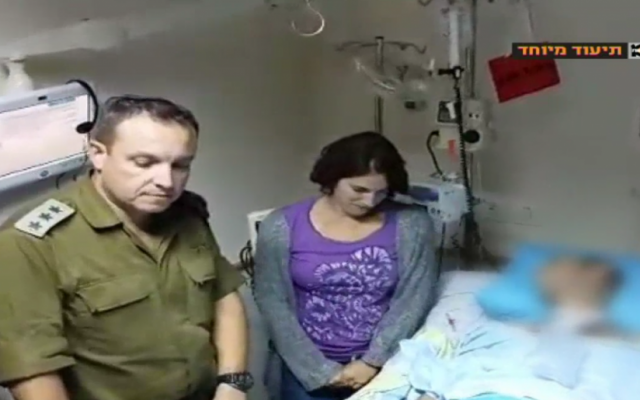 Then Paratroopers Brigade commander Eliezer Toledano appointing Hagai Ben Ari as commander of the Paratroopers reconnaissance battalion during a ceremony in Ben Ari's hospital room. 2014. (Screen capture: Channel 10) 