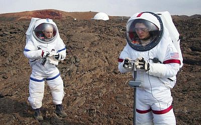 In this May 23, 2014 photo provided by the University of Hawaii, Lucie Poulet, right, uses a geotechnical tool while Annie Caraccio records the data during a previous study outside the domed structure that will house six researchers for eight months in an environment meant to simulate an expedition to Mars, on Mauna Loa on the Big Island of Hawaii.  (Ross Lockwood/University of Hawaii via AP)