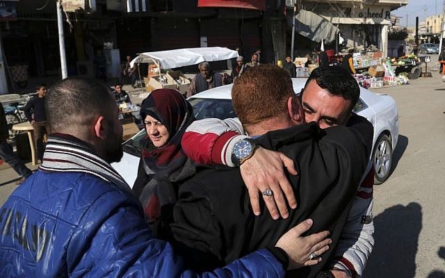 Civilians congratulate each other after the fight between Iraqi security forces and Islamic State militants in a neighborhood recently liberated from the militia on the eastern side of Mosul, Iraq, Tuesday, January 17, 2017. (AP Photo/ Khalid Mohammed)