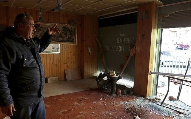 In this Wednesday, Jan. 4, 2017 photo, Karak resident Jamal Saoub points to damage in the Shehab Restaurant where four Jordanian supporters of Islamic State sprayed automatic fire on Dec. 18, 2016, before continuing their rampage inside nearby Karak Castle, Jordan. (AP Photo/Raad Adayleh)