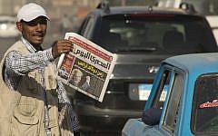An Egyptian newspaper vendor holds copies of local newspapers fronted with a picture of President-elect Donald Trump with Arabic headline that reads, "Trump era", November 10, 2016. (AP Photo/Amr Nabil, File)