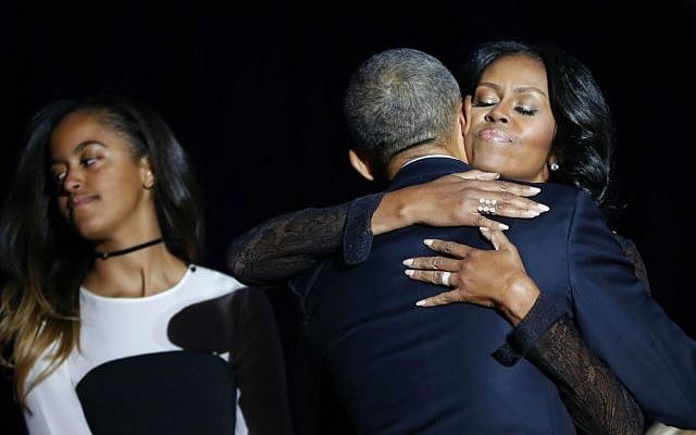 First lady Michelle Obama hugs her husband President Barack Obama after his farewell address at McCormick Place in Chicago, Tuesday, Jan. 10, 2017. Also on stage is their daughter Malia Obama. (AP Photo/Pablo Martinez Monsivais)