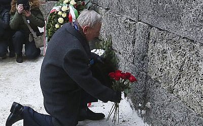 A Holocaust survivor places flowers in commemoration of the people killed by the Nazis at Auschwitz in Oswiecim, Poland on Jan. 27, 2017, the anniversary of the 1945 liberation of the Nazi death camp and International Holocaust Remembrance Day. (AP Photo/Czarek Sokolowski)