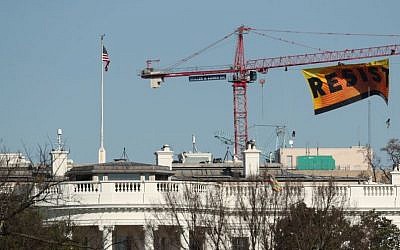Greenpeace protesters unfurl a banner that reads "Resist" at the construction site of the former Washington Post building, near the White House in Washington, Wednesday, Jan. 25, 2017, after police say protesters climbed a crane at the site refusing to allow workers to work in the area. (AP Photo/Andrew Harnik)