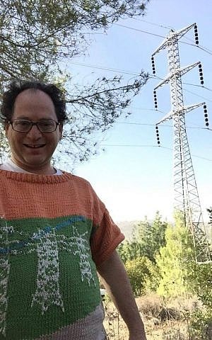 Sam Barsky poses with pylons. This sweater depicts Israeli pylons, which he aesthetically prefers. (Courtesy/Facebook)