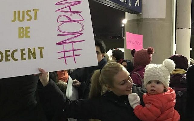 Taylor Clearfield holding a sign, and her daughter, at a protest of the refugee ban at O’Hare International Airport in Chicago, Jan. 27, 2017. (Courtesy of Taylor Clearfield) 