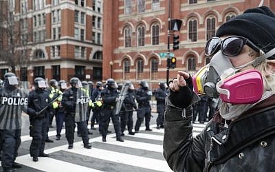 A protester faces off with a line of riot police during a demonstration after the inauguration of President Donald Trump, Friday, Jan. 20, 2017, in Washington. (John Minchillo/AP)