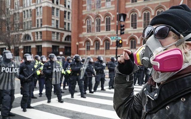 A protester faces off with a line of riot police during a demonstration after the inauguration of President Donald Trump, Friday, Jan. 20, 2017, in Washington. (John Minchillo/AP) 