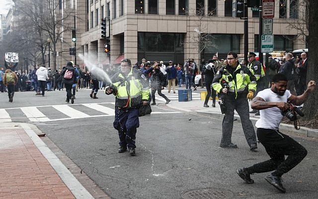 Police officers fire pepper spray at protesters during a demonstration after the inauguration of President Donald Trump, Friday, Jan. 20, 2017, in Washington. (John Minchillo/AP) 