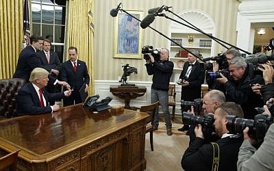 President Donald Trump hands over his pen after signing his first executive order, Friday, January 20, 2017, in the Oval Office of the White House in Washington. (AP/Evan Vucci)