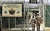 US military guards walk within Camp Delta military-run prison, at the Guantanamo Bay US Naval Base, Cuba,  June 27, 2006. (AP Photo/Brennan Linsley, file)