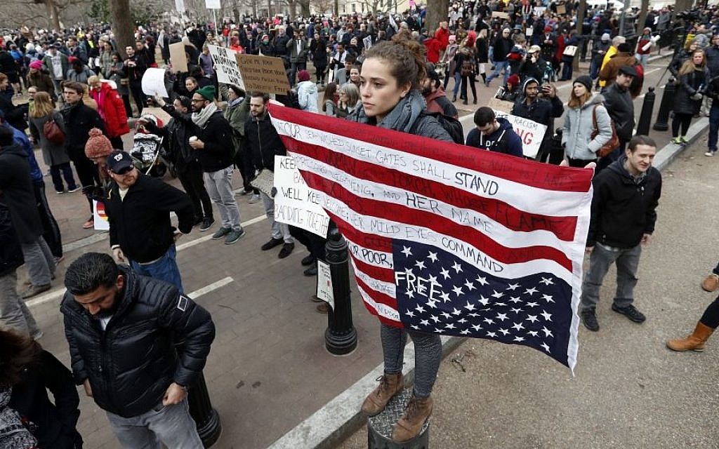 Liz Glusman, from Washington, joins a crowd protesting in Lafayette Park near the White House during a demonstration to denounce President Donald Trump's executive order that bars citizens of seven predominantly Muslim-majority countries from entering the US on Sunday, Jan. 29, 2017, in Washington. (AP /Alex Brandon) Liz Glusman, from Washington, joins a crowd protesting in Lafayette Park near the White House during a demonstration to denounce President Donald Trump's executive order that bars citizens of seven predominantly Muslim-majority countries from entering the US on Sunday, Jan. 29, 2017, in Washington. (AP /Alex Brandon)