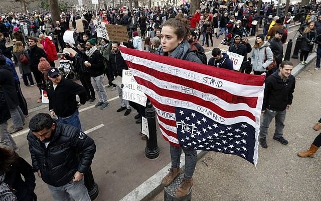 Liz Glusman, from Washington, joins a crowd protesting in Lafayette Park near the White House during a demonstration to denounce President Donald Trump's executive order that bars citizens of seven predominantly Muslim-majority countries from entering the US on Sunday, Jan. 29, 2017, in Washington. (AP /Alex Brandon)