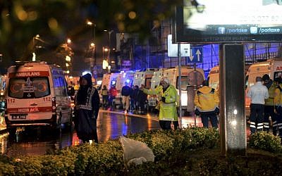 Medics and security officials work at the scene after an apparent terror attack at a popular nightclub in Istanbul, early Sunday, Jan. 1, 2017. (IHA via AP)