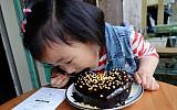 Chinese child eating a home baked UgaUga cake. Picture was uploaded by users on UgaUga's blog on WeChat (Courtesy)