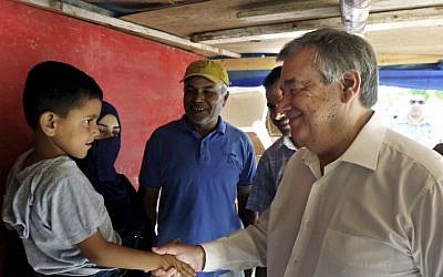 Then United Nations High Commissioner for Refugees Antonio Guterres shakes hands with a Syrian child during his visit to Khaldeh, south of Beirut, Lebanon, June 19, 2016. (AP Photo/Bilal Hussein,)