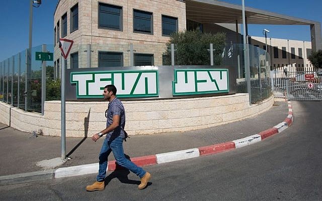 An Israeli worker walks by the offices of Israeli pharmaceutical company Teva Industries in Jerusalem, October 11, 2013. (Yonatan Sindel/Flash90)