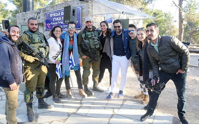 Joseph Waks, fourth from the right, posing with Jewish visitors and soldiers at the Oz Vegaon tent outpost in the West Bank, January 2, 2017. (Bobby Weitzner) Joseph Waks, fourth from the right, posing with Jewish visitors and soldiers at the Oz Vegaon tent outpost in the West Bank, January 2, 2017. (Bobby Weitzner)