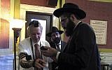 Rabbi Berry Nash, right, prays as Montana Rep. Dave Fern, R-Whitefish, wears boxes containing Torah versus called Tefillin on Wednesday, Jan. 18, 2017 in Helena, Mont. (AP/Matt Volz)